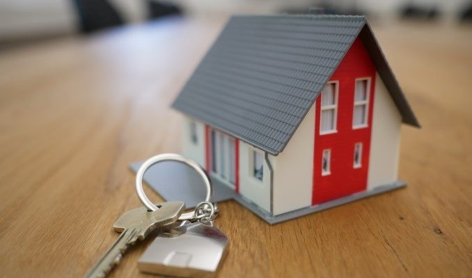 a tiny house and keys on a wooden table